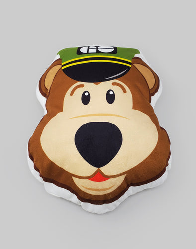 A pillow shaped like a cartoon bear's head, wearing a green GO conductors hat