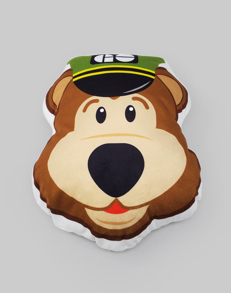 Un oreiller en forme de tête d'ours de bande dessinée, portant un chapeau vert de conducteur de GO